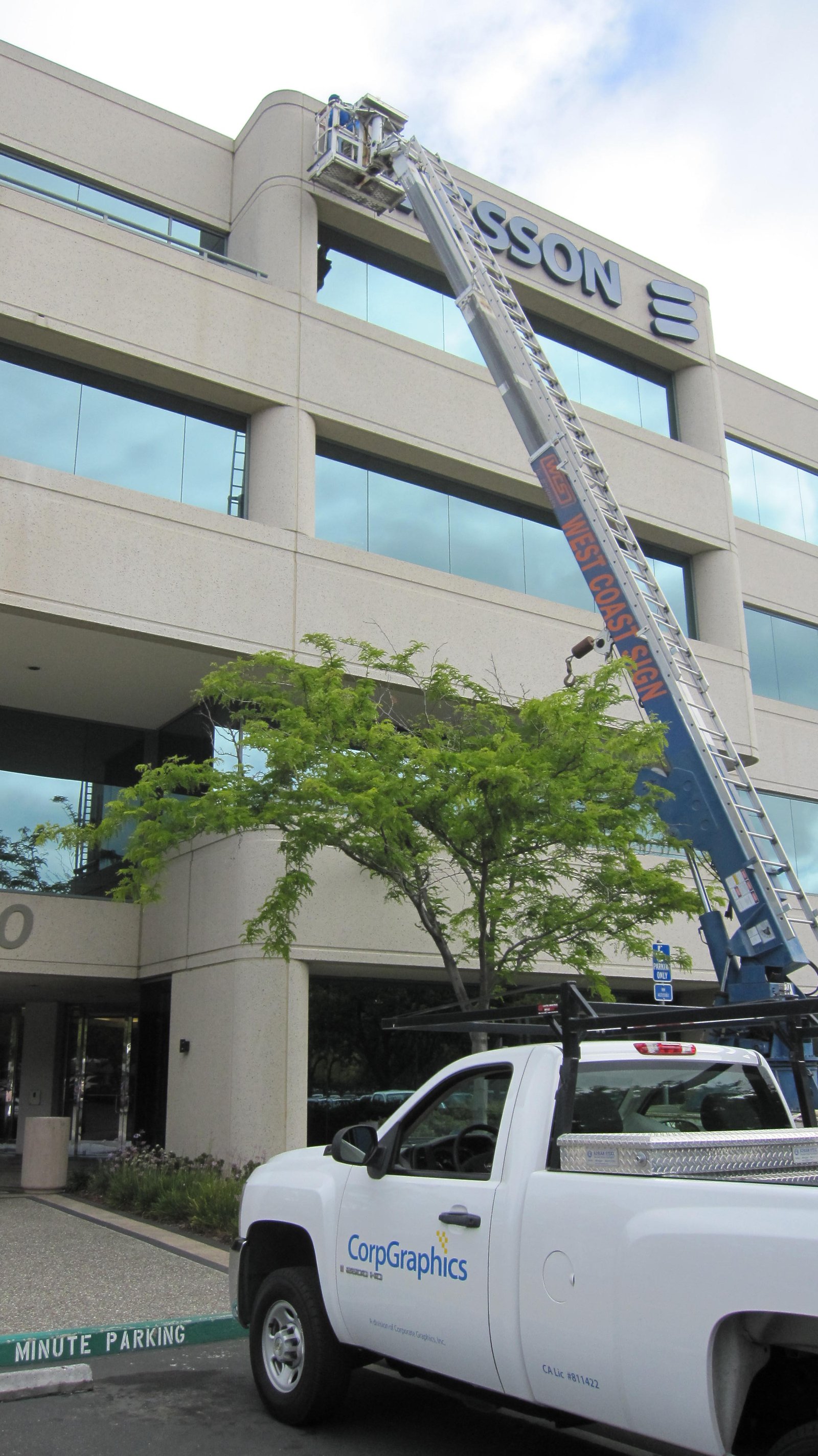 CorpGraphics truck and boom lift installing Ericsson rooftop sign, Pleasanton